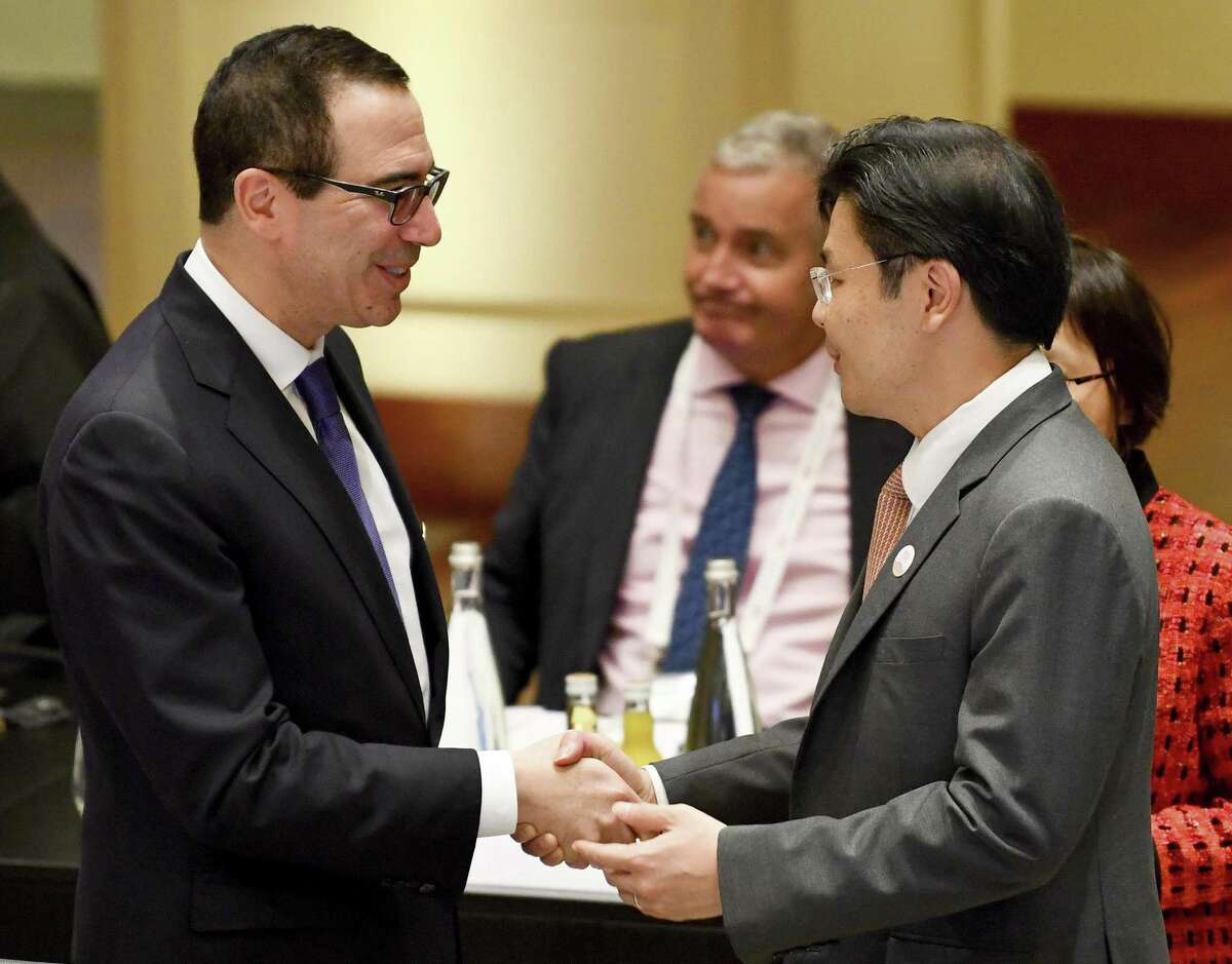 U.S. Treasury Secretary Steven Mnuchin (left) shakes hands with Lawrence Wong, Singapore’s second minister for finance, at the G20 finance ministers meeting this weekend. The U.S. delegation, led by Mnuchin, wanted a reference on the need for trade to be “fair” in the post-meeting communique while China led a defense of the existing rules-based regime under the World Trade Organization. In the end, ministers agreed that “we are working to strengthen the contribution of trade to our economies,” a compromise to salvage what remained of the foundations of an understanding that the G-20 had long largely taken for granted.