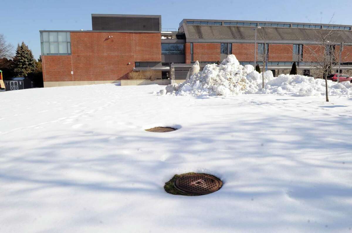 Two man-hole covers can be seen on the playing field at Hamilton Avenue School in the Chickahominy section of Greenwich on Feb. 14. Sylvester Pecora of Chickahominy says that the man-hole covers are part of an underground well system at the school. Pecora says the man-hole covers are unsafe for children playing on the field and Pecora also says that there is a 6-foot incline that runs from the lower end to the upper end of the field that make it unsafe for children at play and causes water to pool towards the lower end of the field and the basketball court.