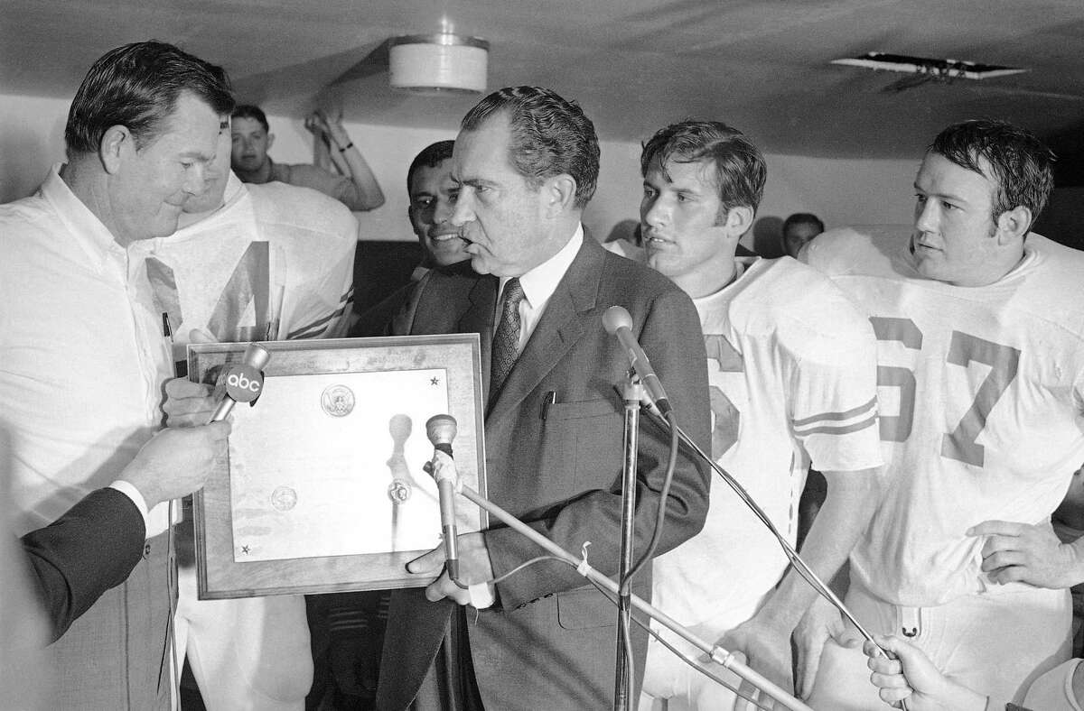 In this Dec. 6, 1969, file photo, President Richard Nixon presents a plaque to Texas football coach Darrell Royal, proclaiming the Longhorns the No. 1 college football team in college football’s 100th year, after their 15-14 win over Arkansas in Fayetteville, Ark.