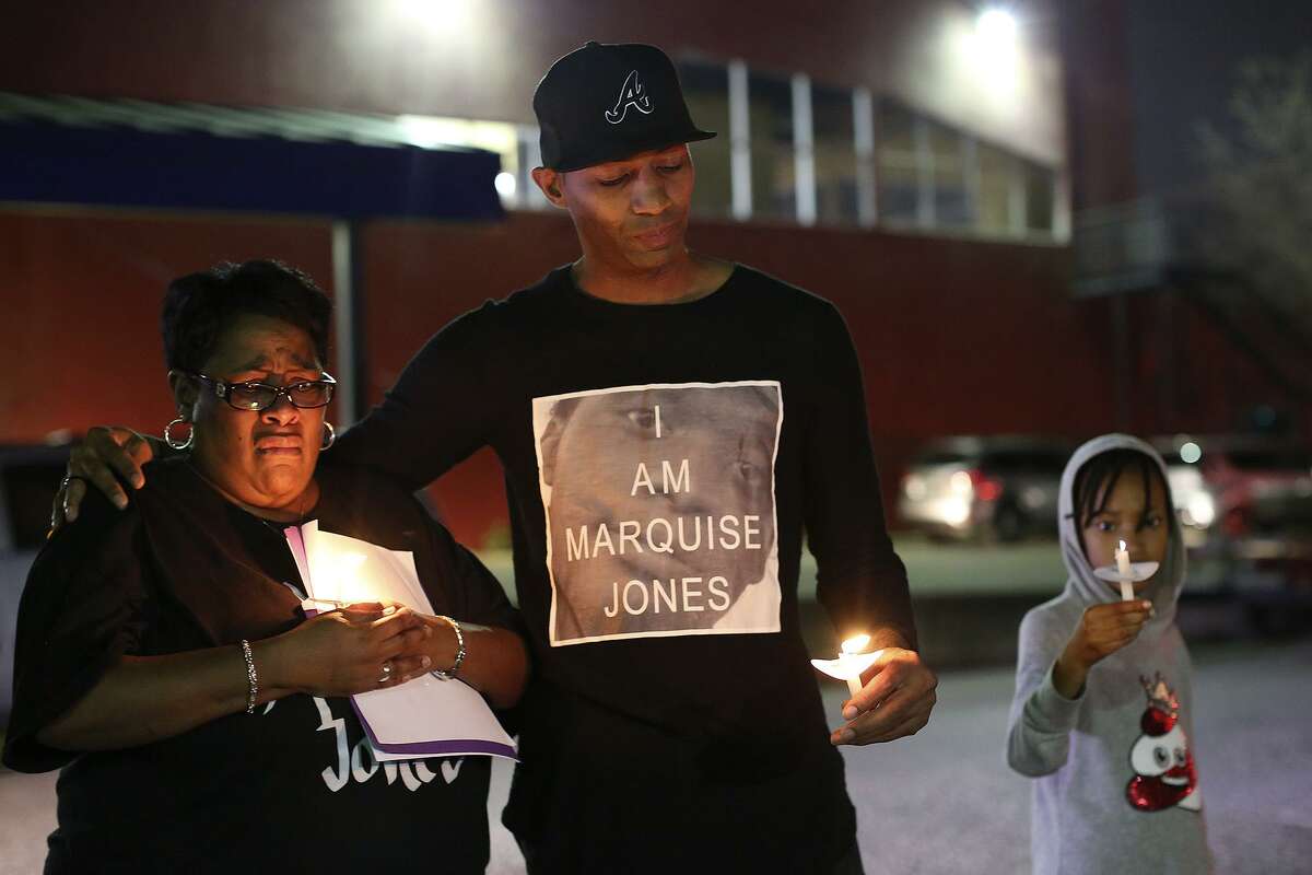 Mike Lowe, of SATX4, with his daughter, Naomi Lowe, 9, puts his arm around Debbie Bush, the aunt of Marquise Jones, after Lowe addressed the crowd gathered for the vigil for the third anniversary of Jones' death outside Chacho's and Chalucci’s restaurant in San Antonio on Feb. 28, 2017.