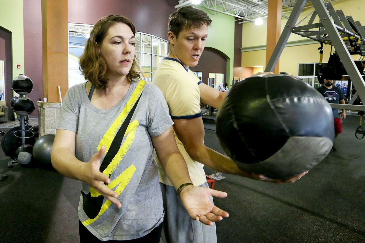 Don and Cindy McGeary, the nation's foremost researchers on the way chronic pain and personal relationships affect each other, do a medicine ball twist while working out together at Gold's Gym, 11761 Bandera Rd., on Sunday, March 5, 2017. MARVIN PFEIFFER/ mpfeiffer@express-news.net
