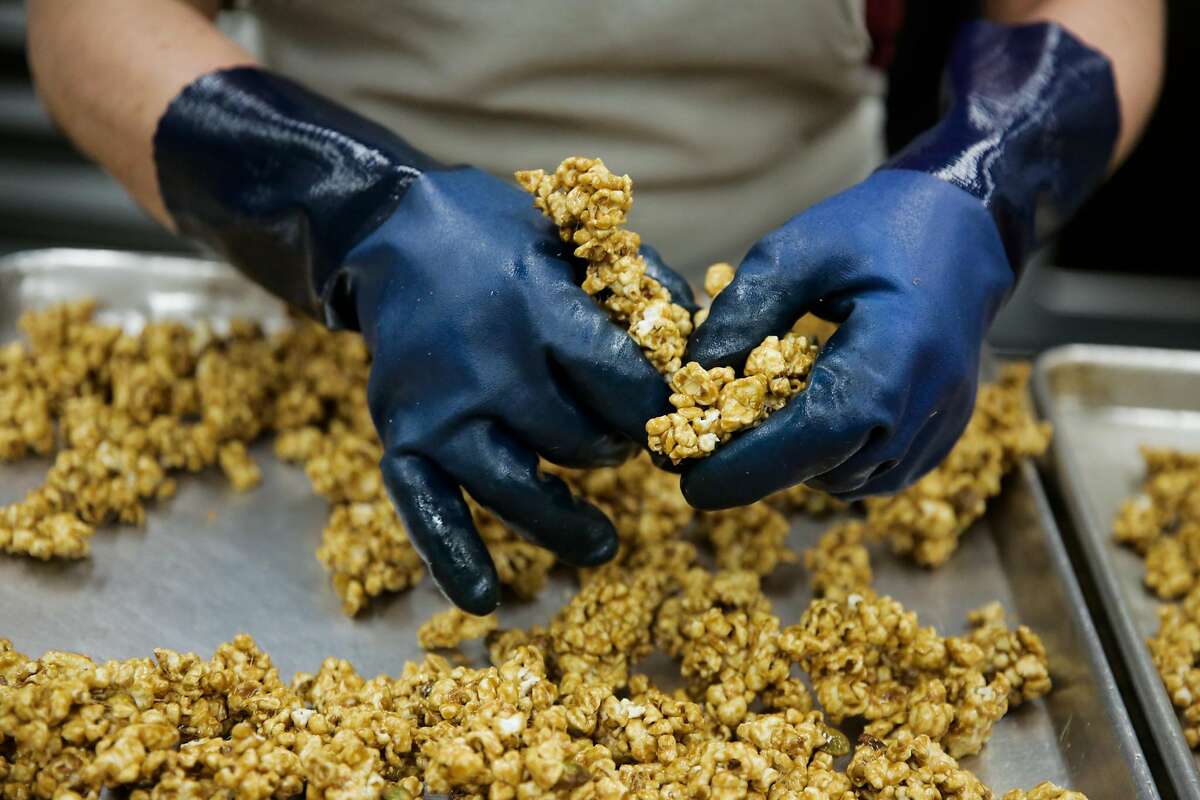 Carmen Sanchez breaks apart popcorn while making pistachio caramel popcorn at caramel company CC Made's production facility in Berkeley, California, on Monday, March 20, 2017.