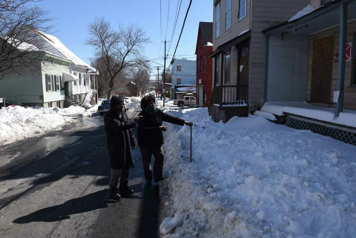 Albany County legislator Luci McKnight, center, and her neighbor, Chuck Moore, left, stand next to a Third Ave. building across from McKnight?s home, far left, that was marked as vacant by the City of Albany on Friday, March 17, 2017, in Albany, N.Y. The markers are posted to help emergency personnel identify buildings that could present a safety risk if entered. Albany County legislator Luci McKnight, who lives on Third Ave., is concerned about the stigma they create. (Will Waldron/Times Union)