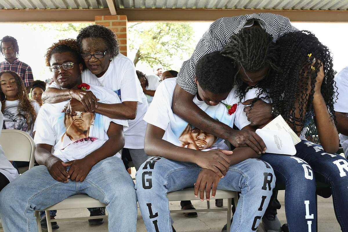 Devin Christian, left, the brother of Patrick Clark, is comforted by their aunt, Darlene Williams, while Matthew Lovings, right, comforts his children and Patrick's siblings, Amari Clark and Ashanti Clark Lovings, during the Celebration of Life for Patrick Clark at MeadowLawn Memorial Park on March 21, 2017.