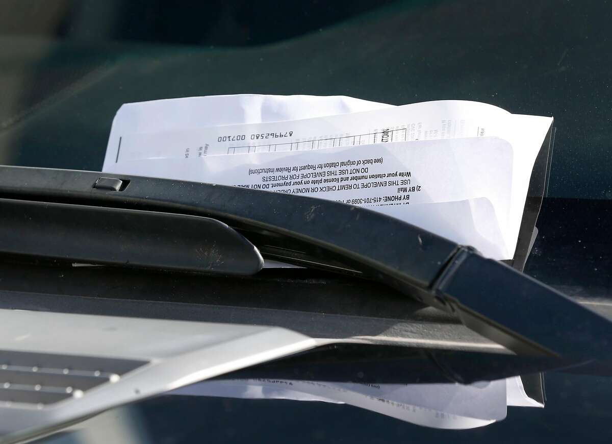 A parking ticket issued by SFMTA parking control officer Trevor Adams is attached to a car windshield on Chestnut Street in the Marina District in San Francisco, Calif. on Tuesday, March 21, 2017.