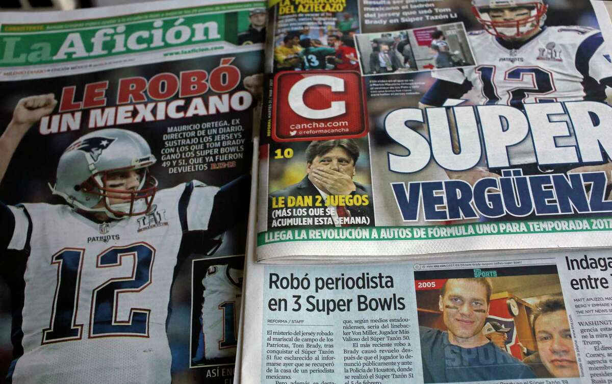 Front pages of Mexican newspapers show headlines and photos about the Tom Brady Superbowl jersey that was allegedly stolen by a Mexican journalist, bottom left on a selfie with Brady, in Mexico City, Mexico March 21, 2017. The headlines read in Spanish "Super embarrassment" top right and "Was stolen by a Mexican," left. (AP Photo/Enric Marti) ORG XMIT: MXEM101