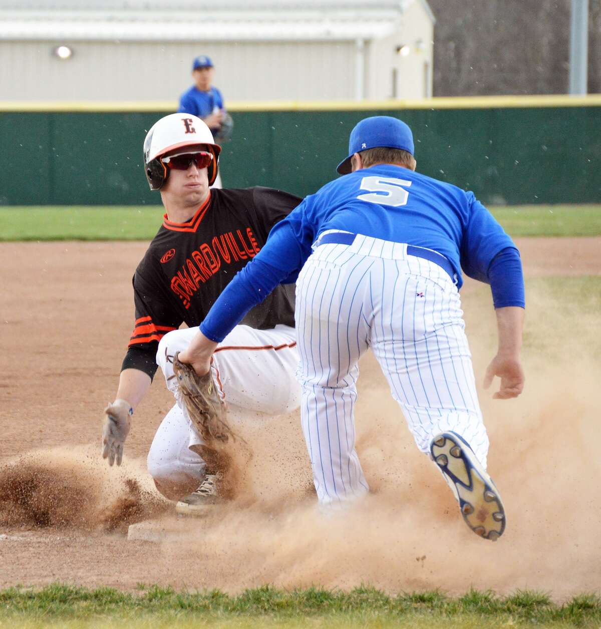 Edwardsville’s Dylan Burris, left, slides safely into third base for a stolen base in the first inning against Greenville.