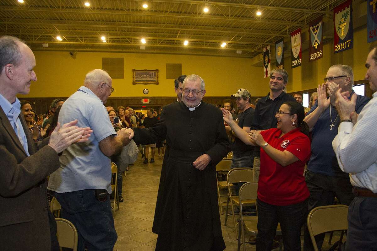 Father Christopher Phillips is greeted with a standing ovation by parishioners at Our Lady of Atonement Catholic Church, Tuesday, March 21, 2017.