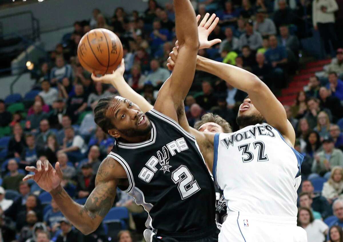 Minnesota Timberwolves' Karl-Anthony Towns, right, gets tangled up with San Antonio Spurs' Kawhi Leonard during the second half of an NBA basketball game Tuesday, March 21, 2017, in Minneapolis. The Spurs won 100-93. (AP Photo/Jim Mone)