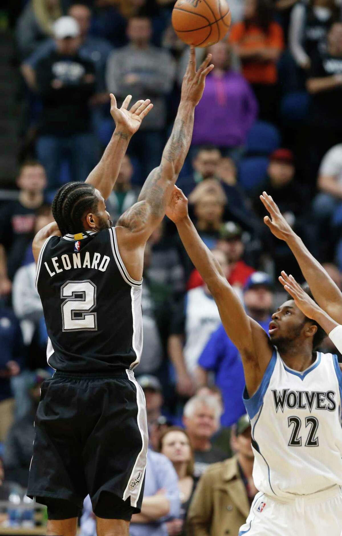 San Antonio Spurs' Kawhi Leonard shoots over Minnesota Timberwolves' Andrew Wiggins, right, during the second half of an NBA basketball game Tuesday, March 21, 2017, in Minneapolis. The Spurs won 100-93. Both Wiggins and Kawhi scored 22 points. (AP Photo/Jim Mone)