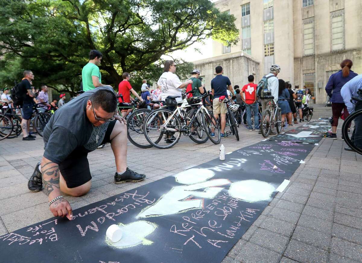 Ricardo Martinez, left, from Pasadena, adds his name to a symbolic bike lane during a rally for the Houston Bike Plan at City Hall, Tuesday, March 21, 2017, in Houston.