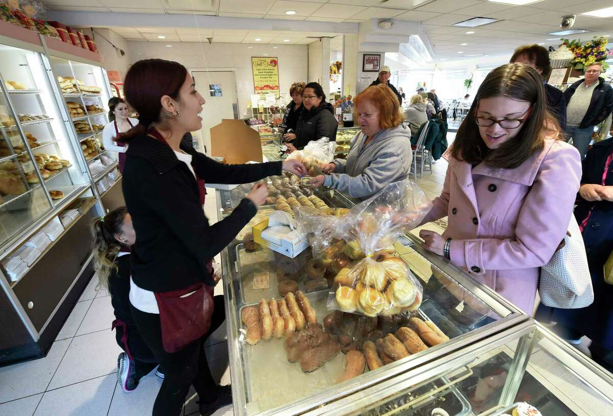 Katie Johnson, left assists a customer as business was extremely heavy the day before the Thanksgiving holiday Wednesday morning Nov. 25, 2015 at the Bella Napoli Bakery in Latham, N.Y. (Skip Dickstein/Times Union)