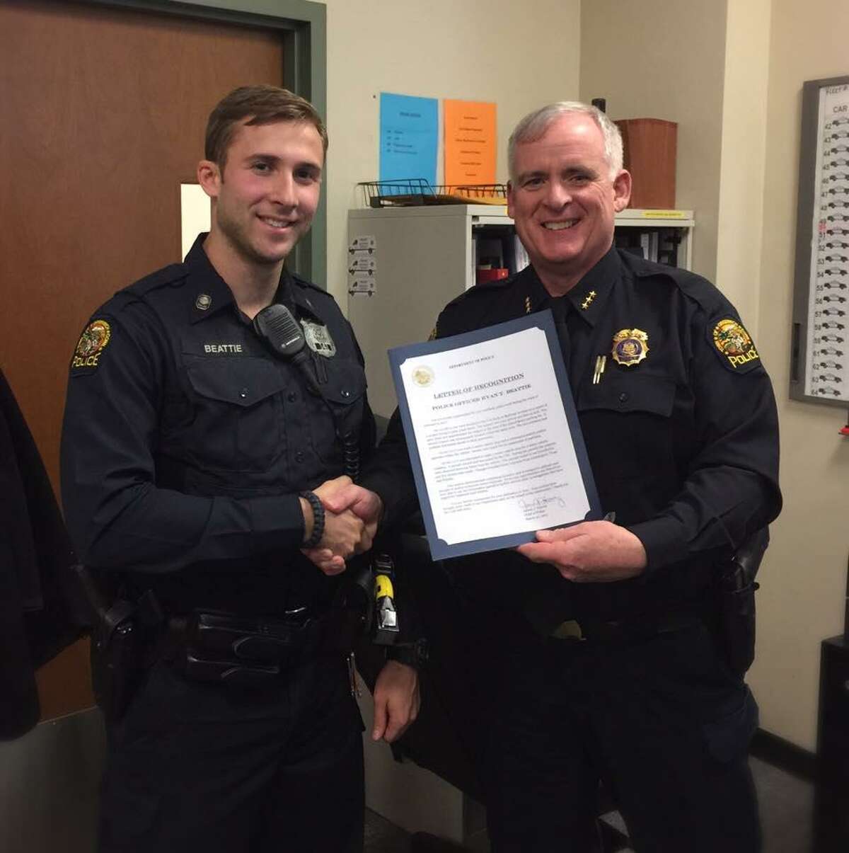 Greenwich Police Officer Ryan Beattie, left, is congratulated by Police Chief James Heavey for garnering “Officer of the Month” honors.