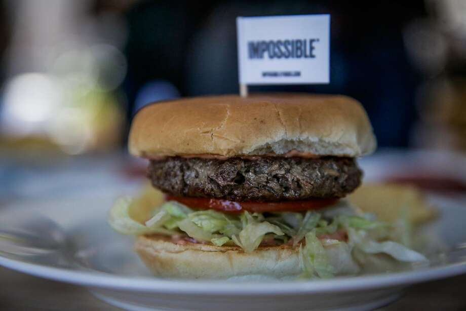 a non-meat burger made by impossible foods rests on a plate