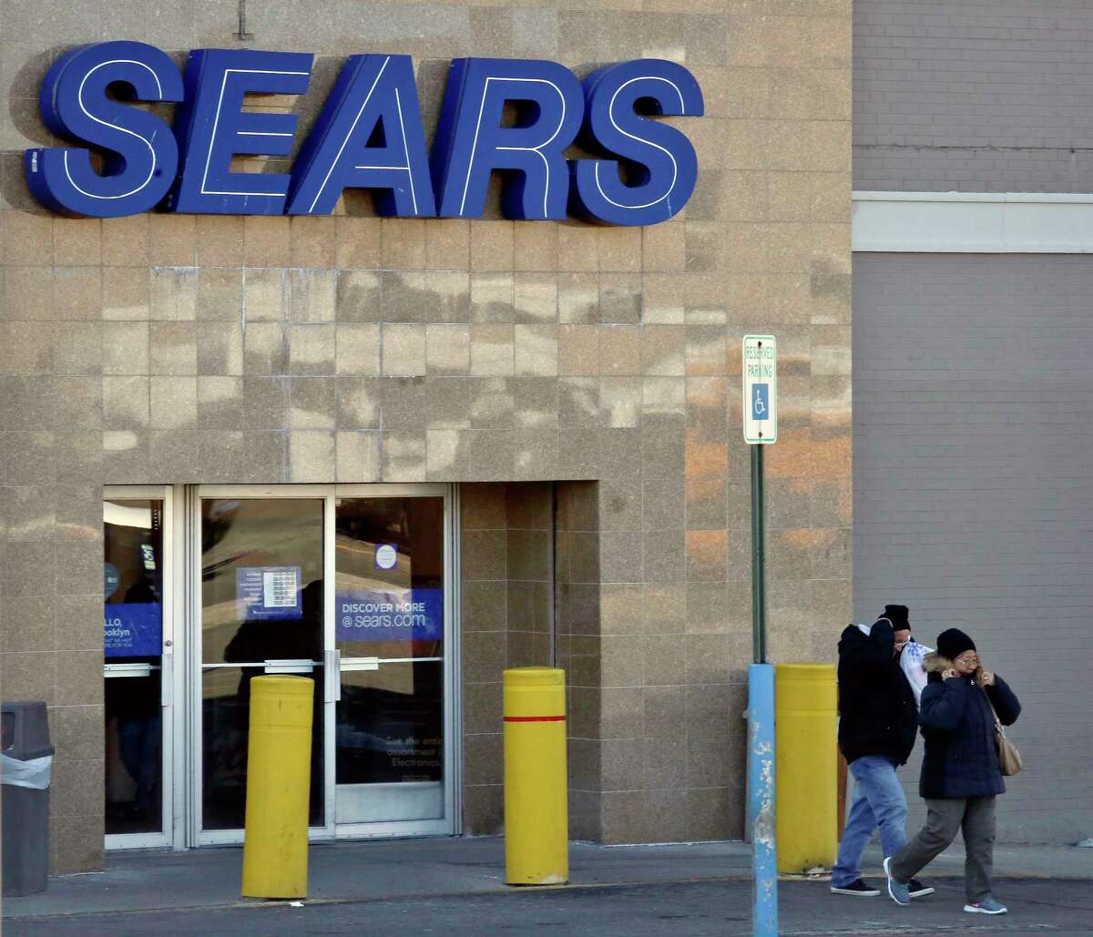 People walk out of a Sears department store in Brooklyn's Flatbush neighborhood, Wednesday, March 22, 2017, in New York. Sears, once the monolith of American retail, says that there is "substantial doubt" that it will be able to keep its doors open. Company shares tumbled more than 12 percent Wednesday. (AP Photo/Bebeto Matthews)