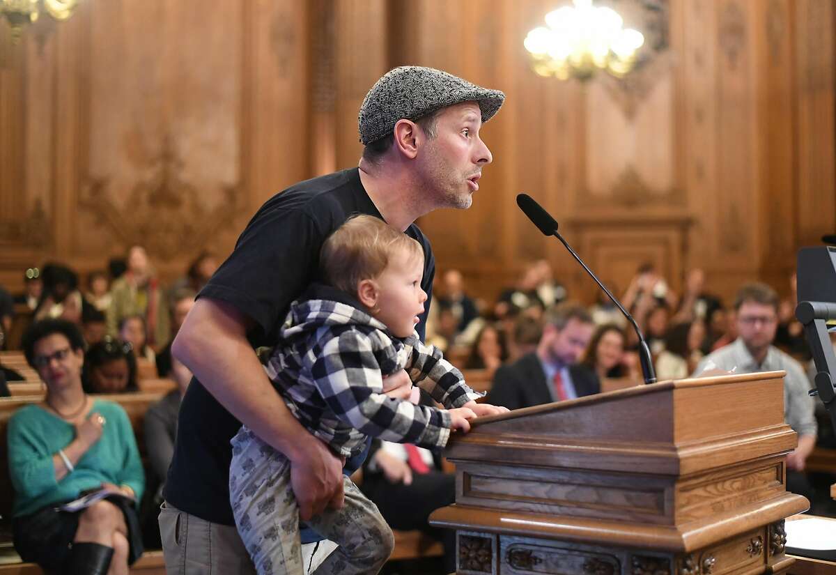 2017年3月22日，周三，旧金山，在监事会听证会上，莱昂·苏丹老师抱着他2岁的儿子泰迪·苏丹，倡导负担得起的教师住房。
