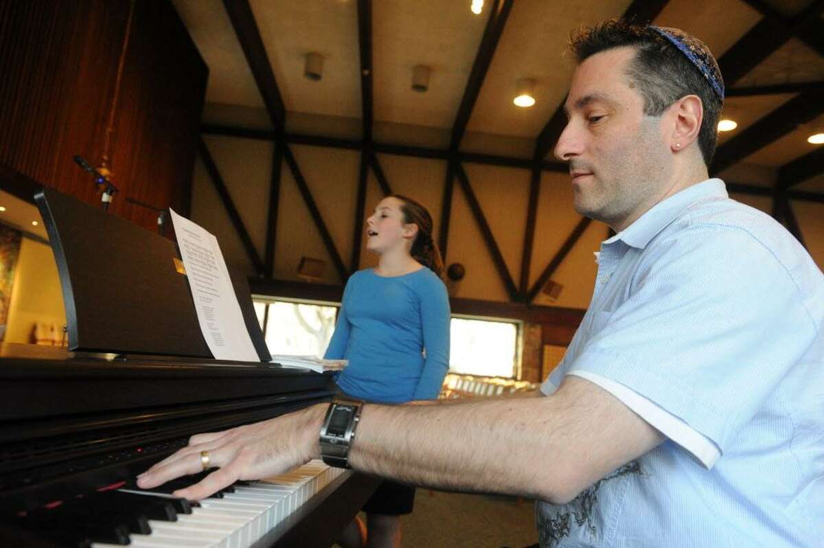 Fkanked by his daughter Alexandra Cahr, Jonathan Cahr leads the youth choir practice as they prepare for the Holocaust Remembrance Day Commemoration at Temple Sinai in Stamford, Conn., April 2, 2012. The concert is open to the public and will take place on Thursday April 19th at 7 P.M. featuring Anita Schorr, a child Holocaust survivor, as the guest speaker.