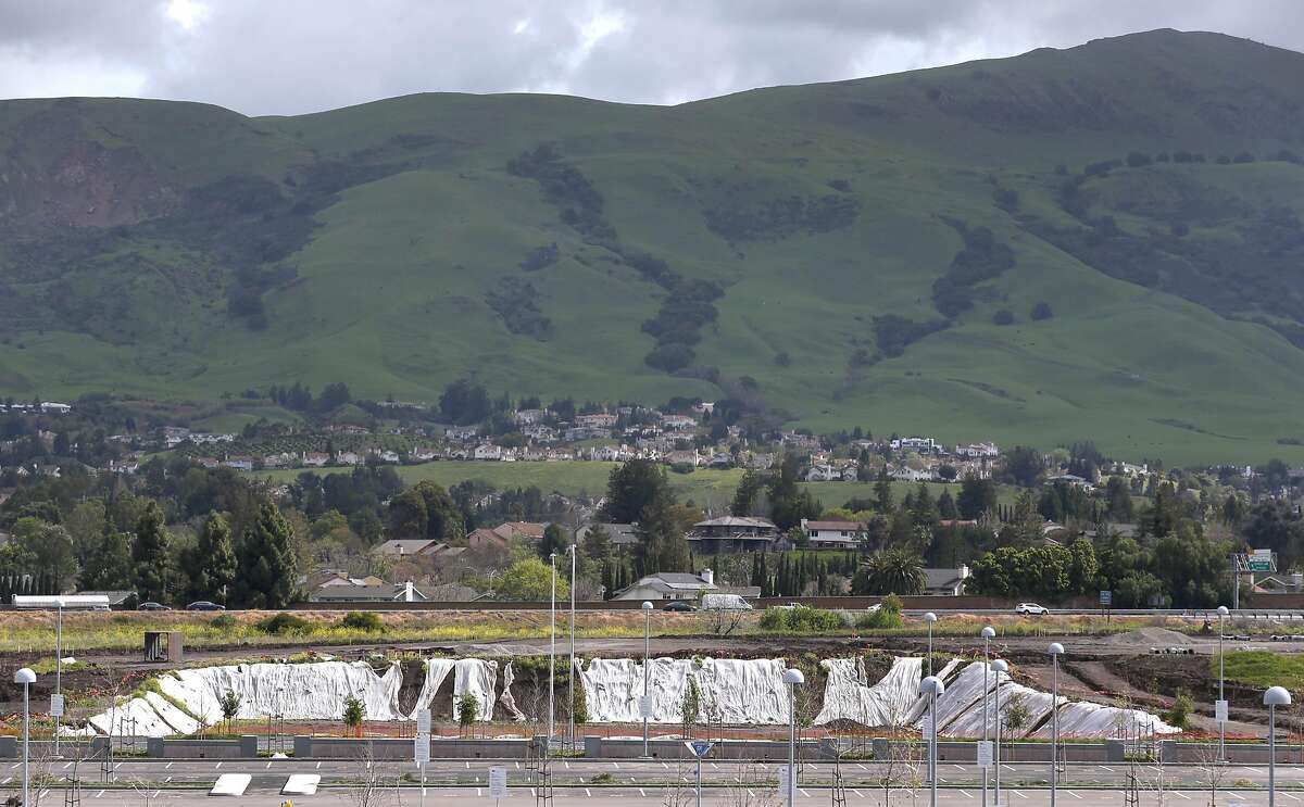 Mission Peak and green hills rise above an Innovation District development project and the Warm Springs BART station in Fremont, Calif. on Wednesday, March 22, 2017. The new station in south Fremont opens for revenue service on Saturday after years of delays.