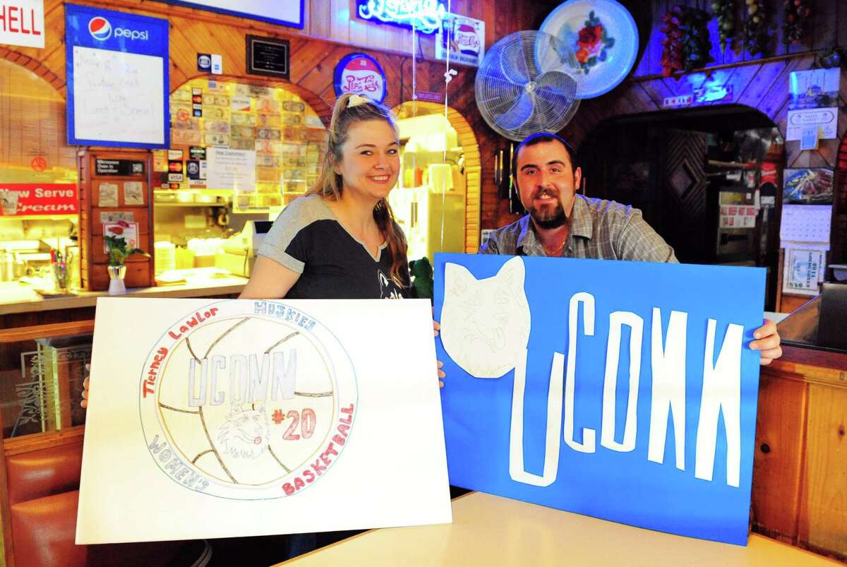 J.R.B.'s Family Restaurant employee Monica Coddington and manager John Kahyaoglu pose with posters Coddington made to hang at the establishment in downtown Ansonia, Conn., on Tuesday Mar. 21, 2017. Ansonia folks and businesses are inspired by UConn women's basketball player Tierney Lawlor, who grew up in Ansonia.
