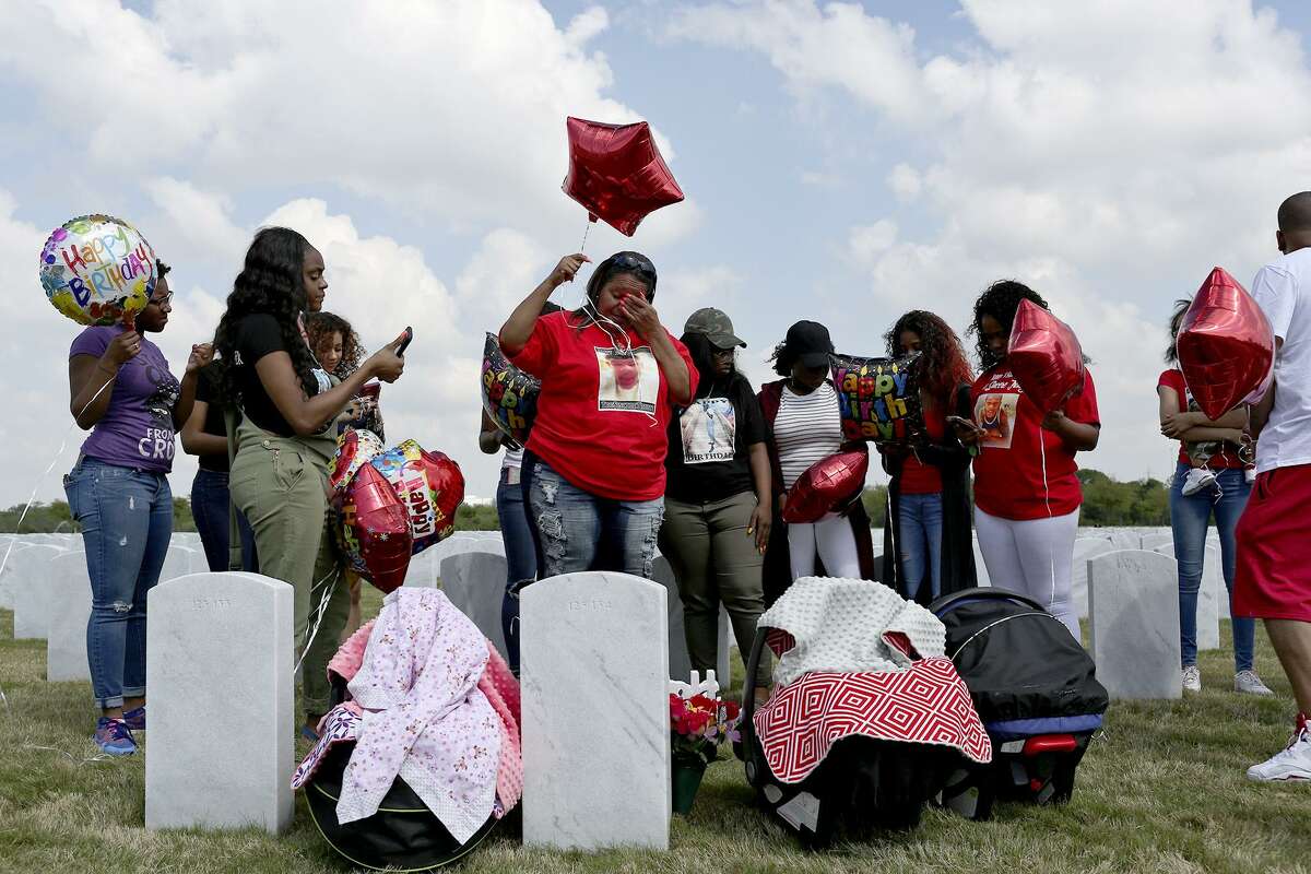 Olivia Fenner, center, gathers with friends and family for a balloon release for her son, Tru Sincere Trusty, on what would have been his 18th brithday at Fort Sam Houston National Cemetery on Saturday, March, 18, 2017. Trusty was shot and killed when he was 16- years-old in September of 2015.