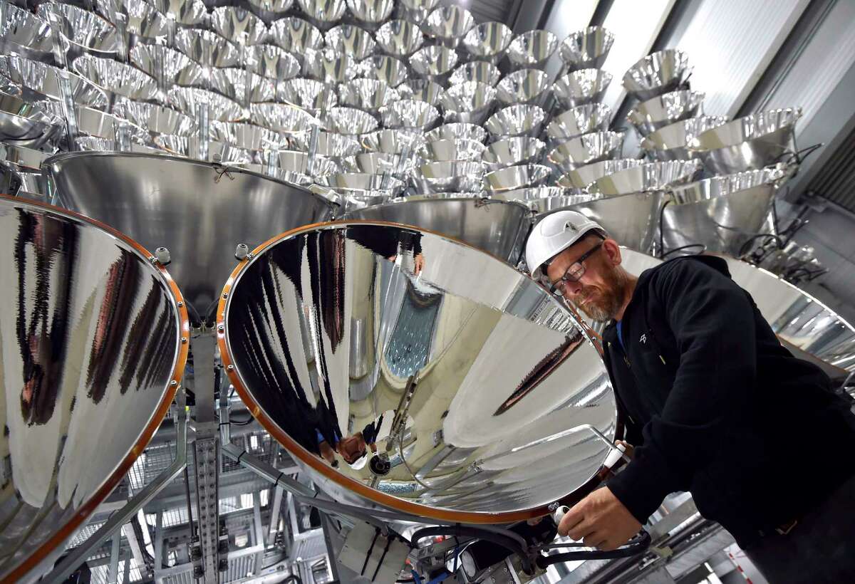 In this March 21, 2017 photo engineer Volkmar Dohmen stands in front of xenon short-arc lamps in the DLR German national aeronautics and space research center in Juelich, western Germany. The lights are part of an artificial sun that will be used for research purposes. (Caroline Seidel/dpa via AP)