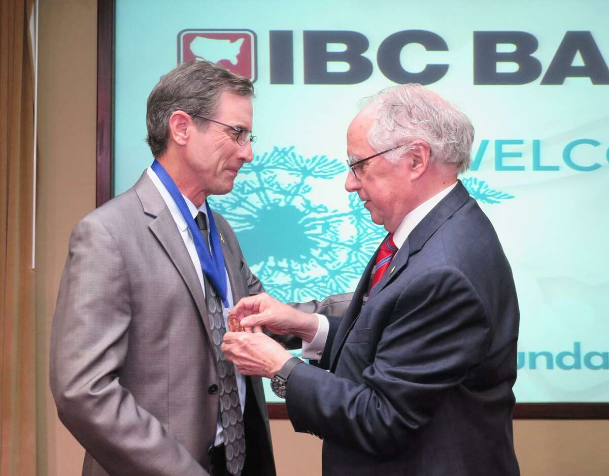 Bill Hrncir recibe el Premio Jefferson Voluntario del Año 2017 Volunteer de parte del director de LMT Bill Green durante una ceremonia llevada a cabo en el IBC Annex Ballroom.