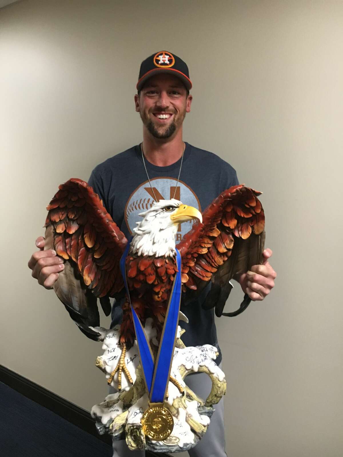 Astros reliever Luke Gregerson poses with the eagle and gold medal Friday morning outside the Astros' spring training clubhouse in West Palm Beach, Fla.