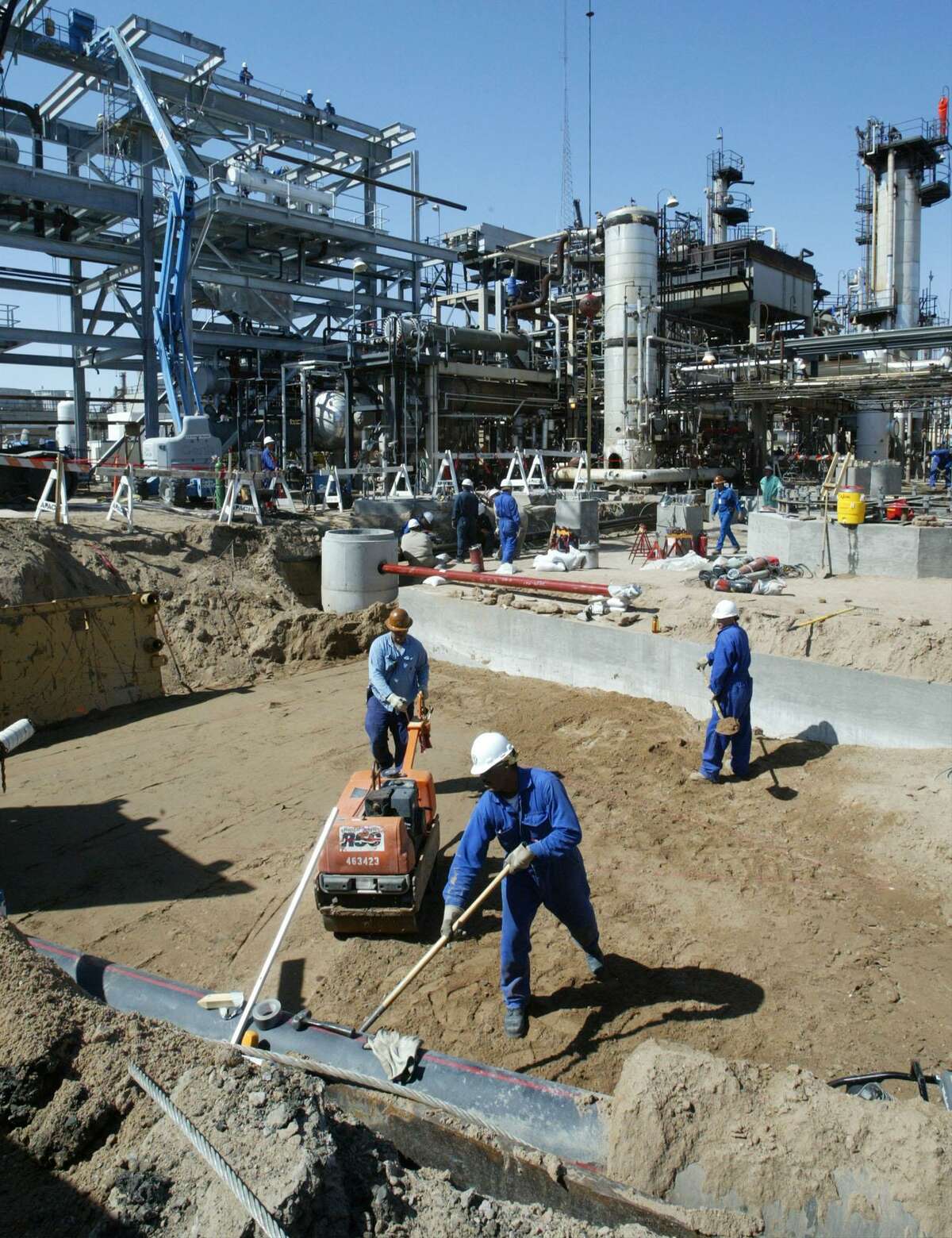 Workers build a concrete base to support a vessel in an ultra-low sulfur diesel fuel refining area at the Western Refining Inc. facility in El Paso in this 2005 file photo. Roughly 80 percent of Western Refining shares at a special meeting approved the $4.1 billion merger with Tesoro.