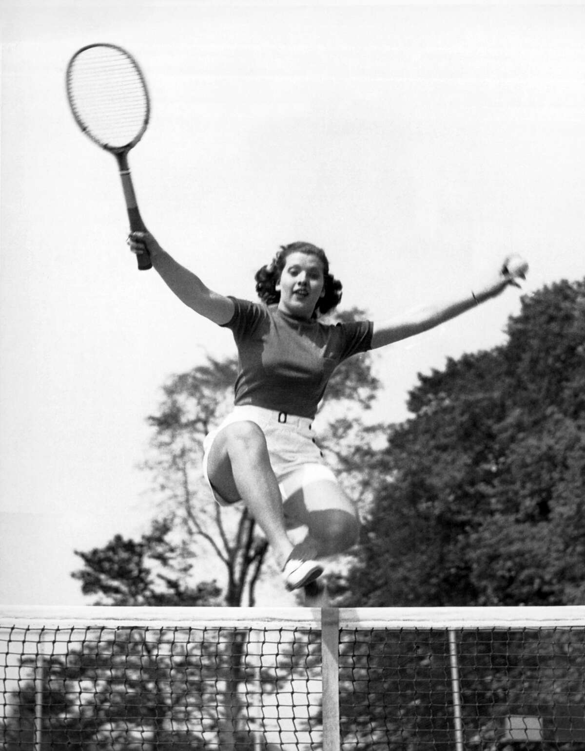 The 18 year old woman leaping over the tennis net was named 'Typical American Girl Athlete' by the Athletic Committee of the Longshore Club in Westport, Westport, Connecticut, May 23, 1936. (Photo by Underwood Archives/Getty Images)