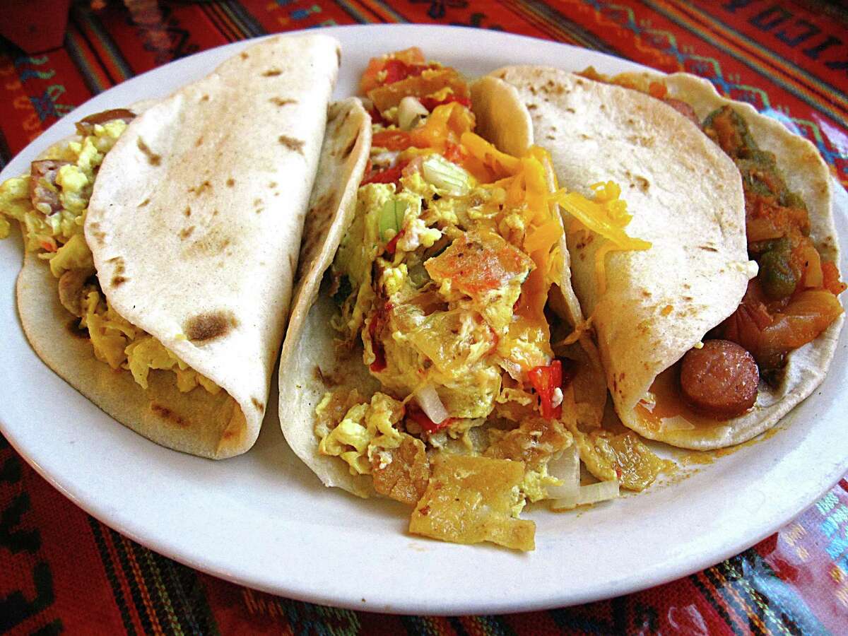 A trio of breakfast tacos on handmade flour tortillas, From left: Country sausage and egg, chilaquiles and weenies in salsa. From Los Campos Dos Hermanos.