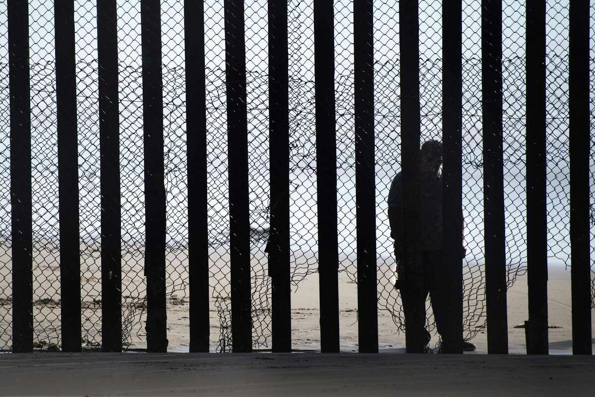A man standing on the Mexico side of a border fence separating the beaches at Border Field State Park, in San Diego, California in February. A pragmatic immigration policy would find a way to let more workers in because a declining birth rate in the U.S. means fewer workers.