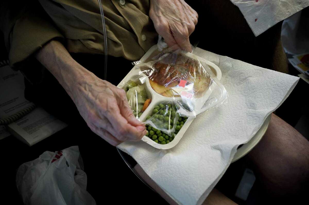 A disabled pilot opens a prepared meal at his home in Portland, Ore., July 12, 2010. Meals on Wheels has been the subject of many peer-reviewed studies in the medical literature, most of which show that the program improves the quality of people’s diet, increases their nutrient intake and reduces their food insecurity and nutritional risk.