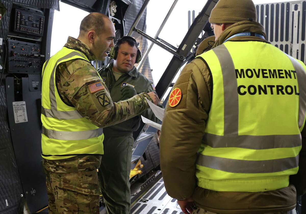 Master Sgt. Eric Mungia, center, and Army Maj. Nathan Colvin talk with Latvian soldiers at the airport in Riga, Latvia, Wednesday, March 1, 2017. Mungia, with the Air Force Reserve?•s Alamo Wing based at Lackland, was part of a crew on a C-5M Super Galaxy that transported aircrafts, equipment and troops to Latvia as part of Operation Atlantic Resolve.