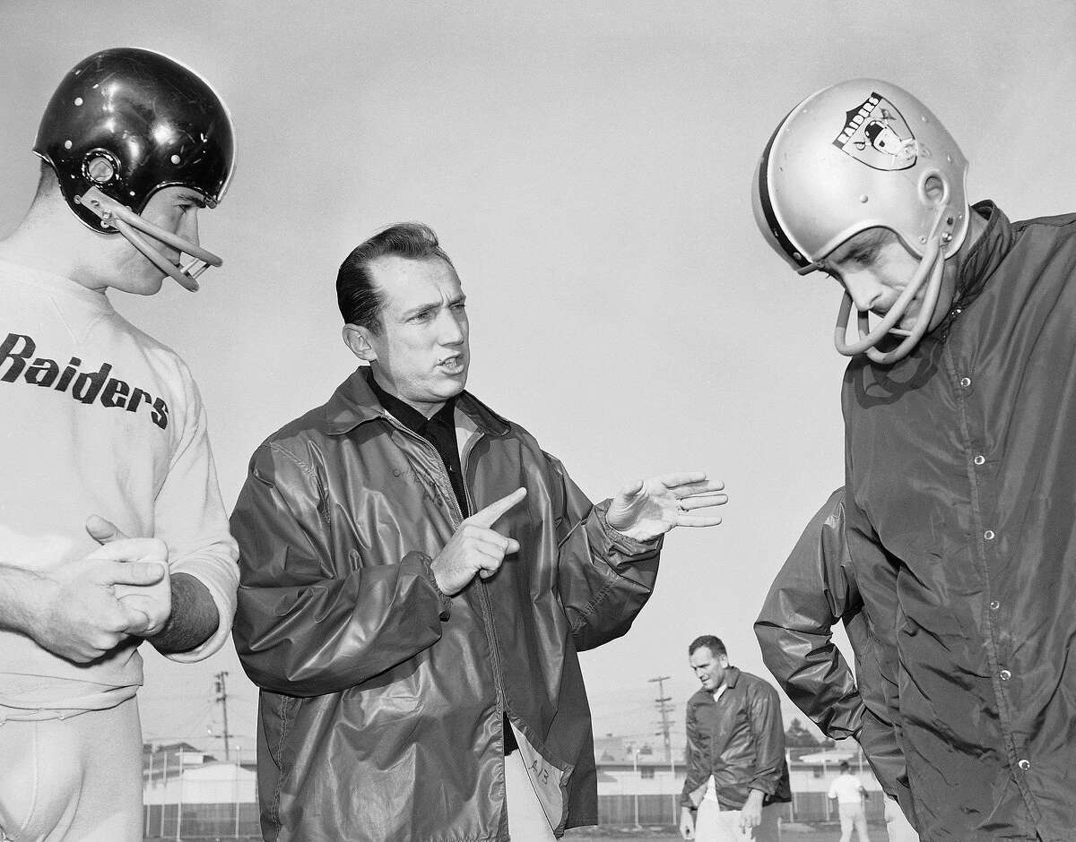 In this Dec. 18, 1963 file photo, Al Davis, center, head coach of the American Football League's Oakland Raiders, talks with players at the team's home practice field in Oakland, Calif. Davis, the Hall of Fame owner of the Oakland Raiders known for his rebellious spirit, has died. The team announced his death at age 82 on Saturday, Oct. 8, 2011.