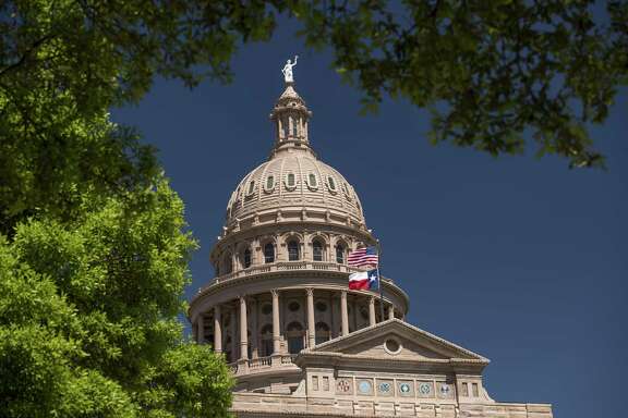 An American flag flies with the Texas state flag outside the Texas State Capitol building in Austin. (Photo: David Paul Morris/Bloomberg)