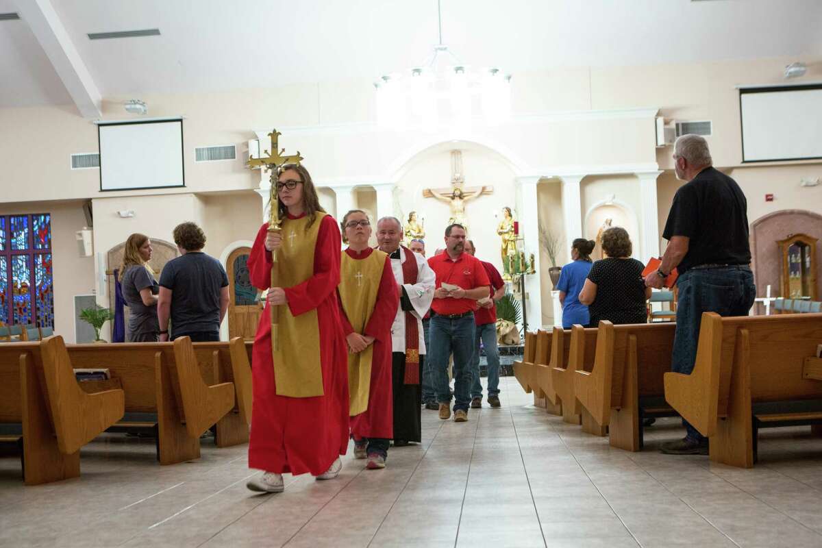 Amber Kindkead, 17, carries the cross out at the end of the service at the St Ann's Catholic Church in La Vernia, Texas