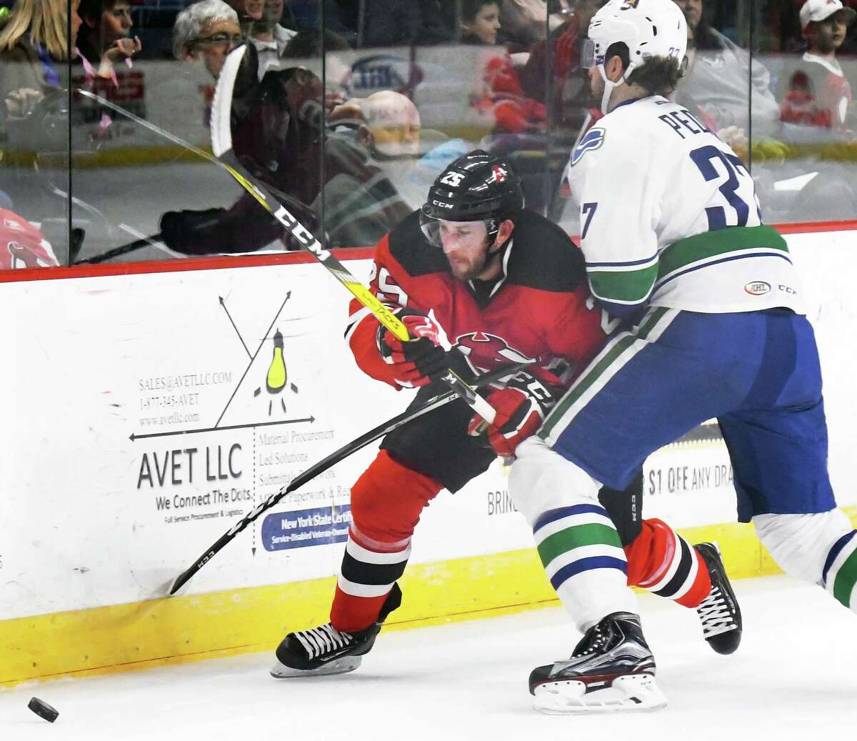 Albany Devils' #25 Nick Lappin, left, fights past Utica Comets' #37 Andrey Pedan during Friday's game at the Times Union Center March 24, 2017 in Albany, NY. (John Carl D'Annibale / Times Union)