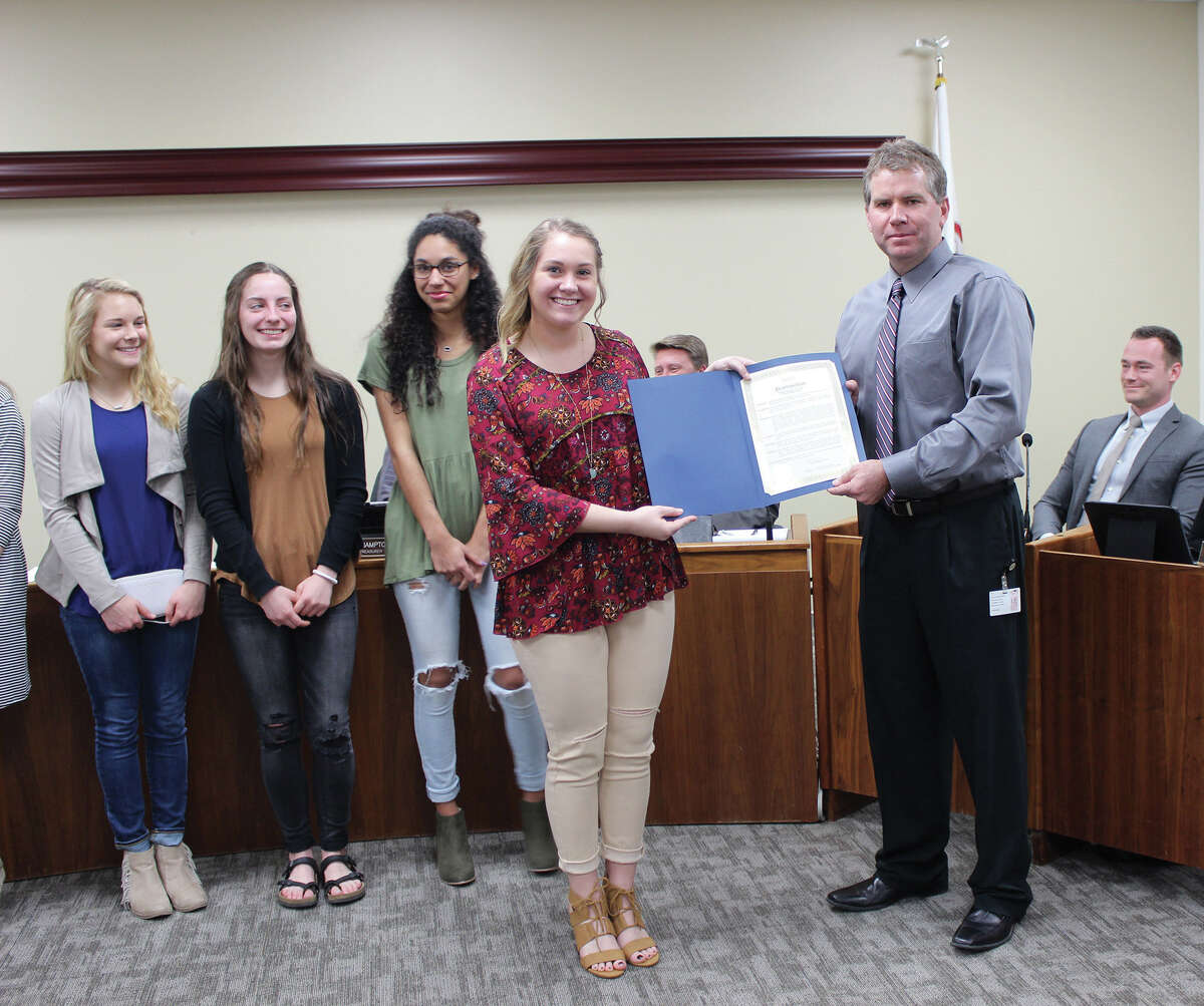 Edwardsville Mayor Hal Patton awarded the Edwardsville High School Varsity Cheerleading team with a proclamation, recognizing the team's efforts over the course of their cheerleading season.