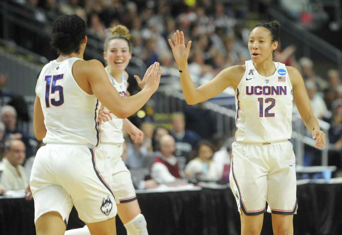 UConn teammates Gabby Williams (15), Katie Lou Samuelson (33), and Saniya Chong (12) celebrate during No. 1 UConn's 86-71 win over No. 4 UCLA in the 2017 NCAA Division I Women's Basketball Championship Regional Semifinal game at Webster Bank Arena in Bridgeport, Conn. Saturday, March 25, 2017.