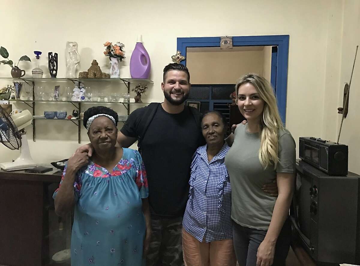 Yonder Alonso and his wife, Amber, right, met the neighbors who watched him as a child, Paula, left, and Emillia, second from right, during a trip to Cuba.