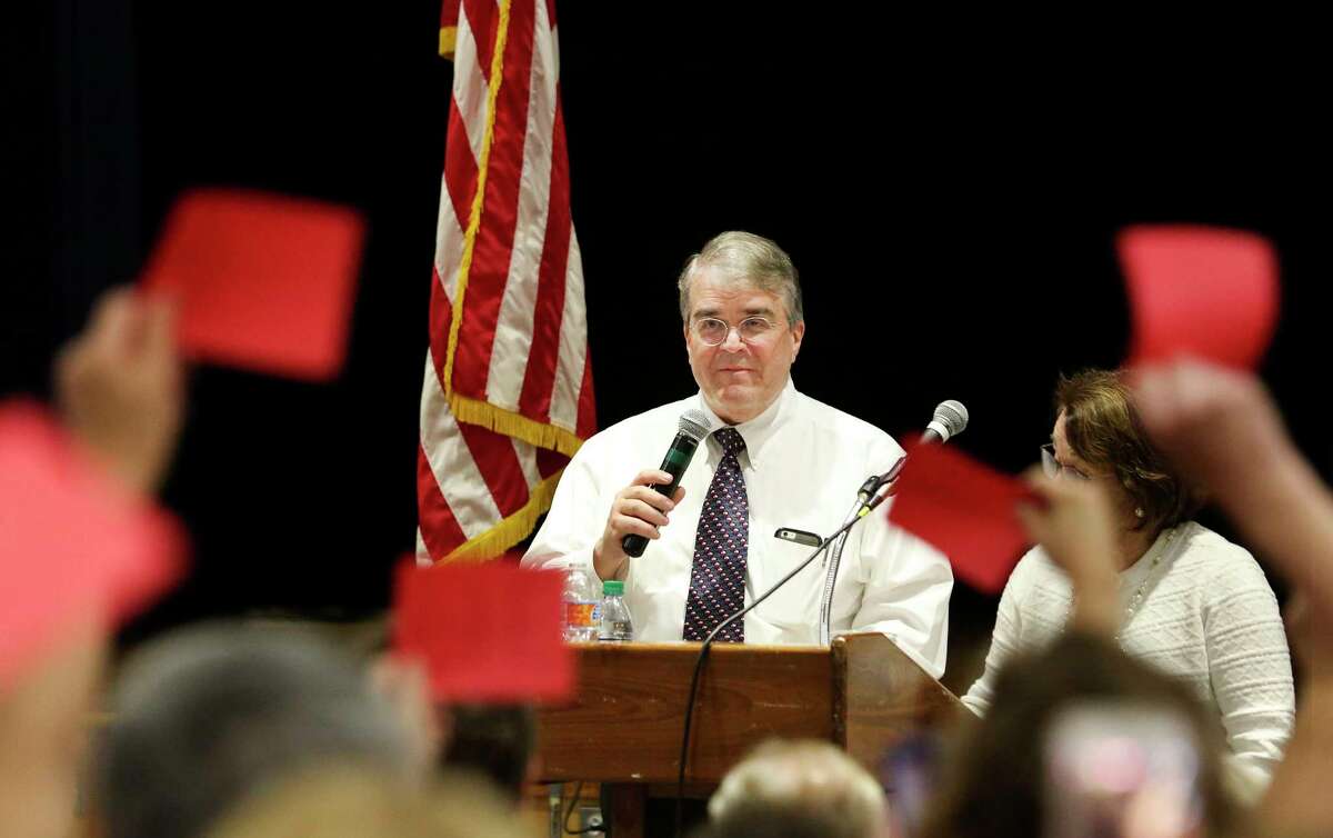U.S. Rep. John Culberson's answer meets with disapproval, as indicated by the red papers held up by constituents at a town hall Saturday.