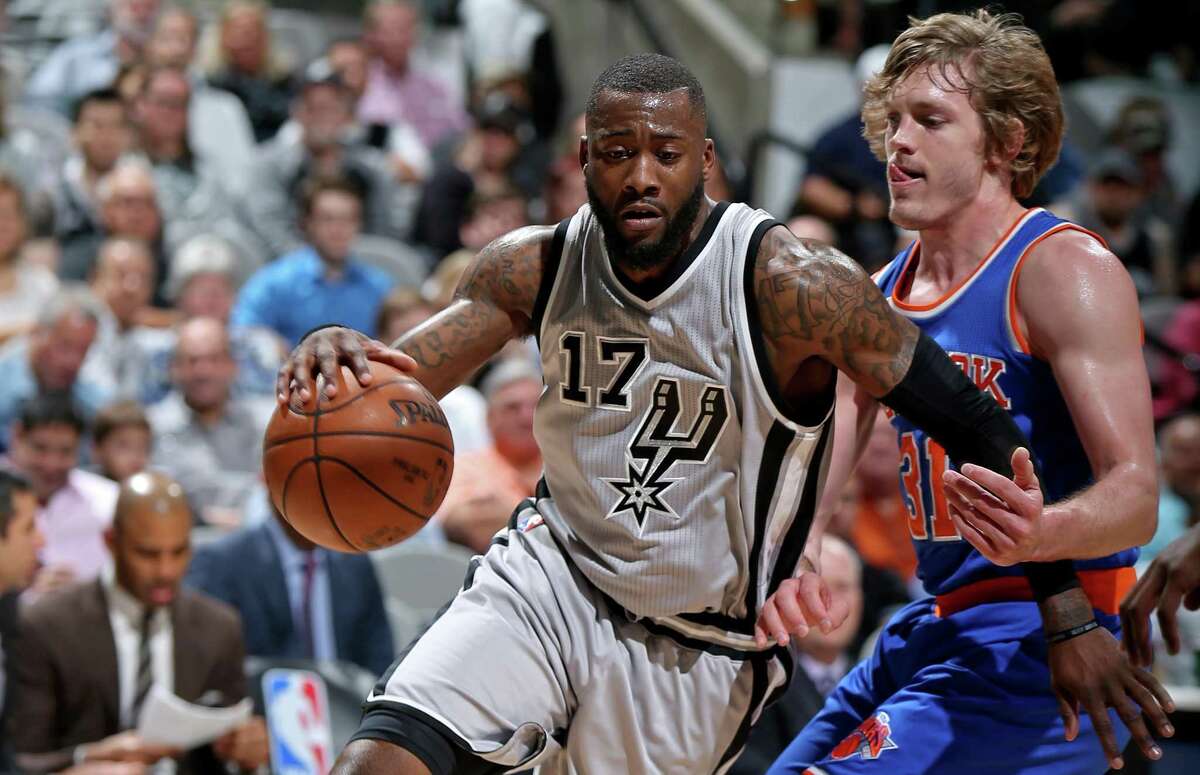 Spurs’ Jonathon Simmons drives around the New York Knicks’ Ron Baker during first half action on March 25, 2017, at the AT&T Center.