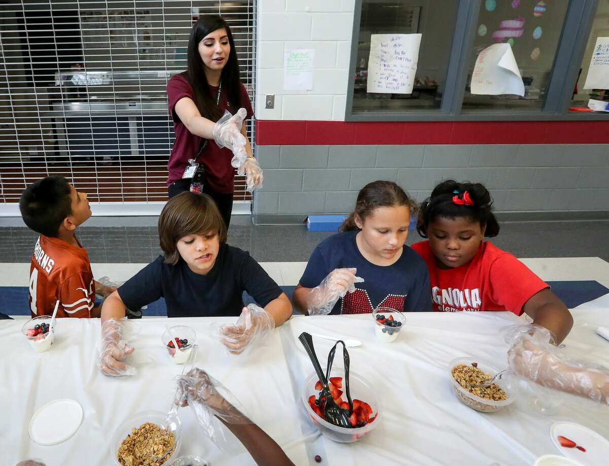 Samantha Torres, rear, a nursing student from Alvin Community College and activity coordinator, gives a lesson on nutrition to Isaac Pedraza, front from left, Joaquin Izaguirre, Josee Buchheight and Lori Taylor during an after-school program at Magnolia Elementary School, Friday, March 24, 2017, in Pearland. ( Jon Shapley / Houston Chronicle )