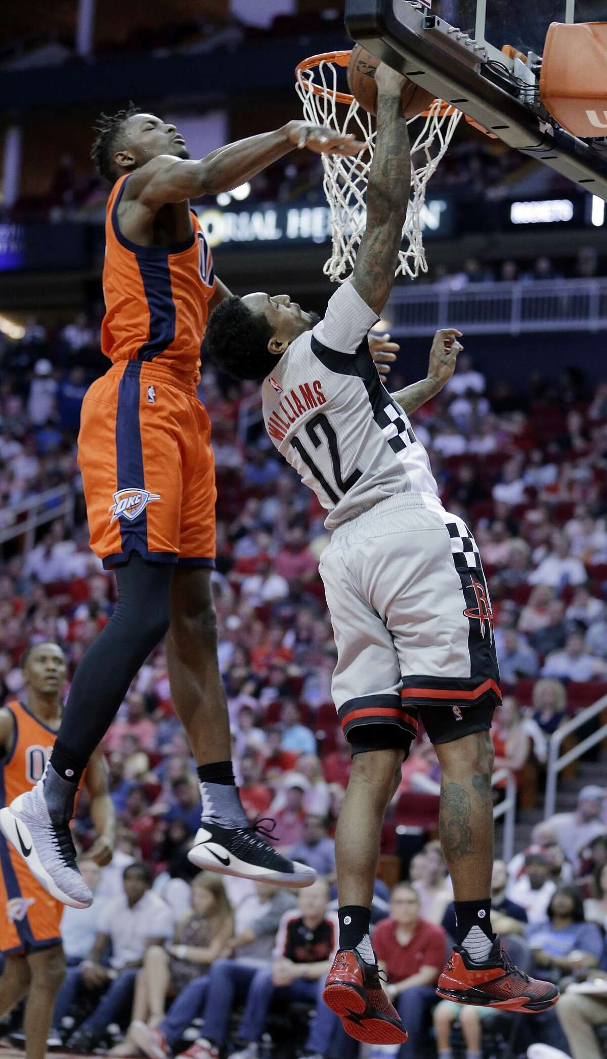 Oklahoma City Thunder's Jerami Grant (9) bats away a shot attempt by Houston Rockets' Lou Williams (12) during the second half of an NBA basketball game in Houston, Sunday, March 26, 2017. (AP Photo/Michael Wyke)
