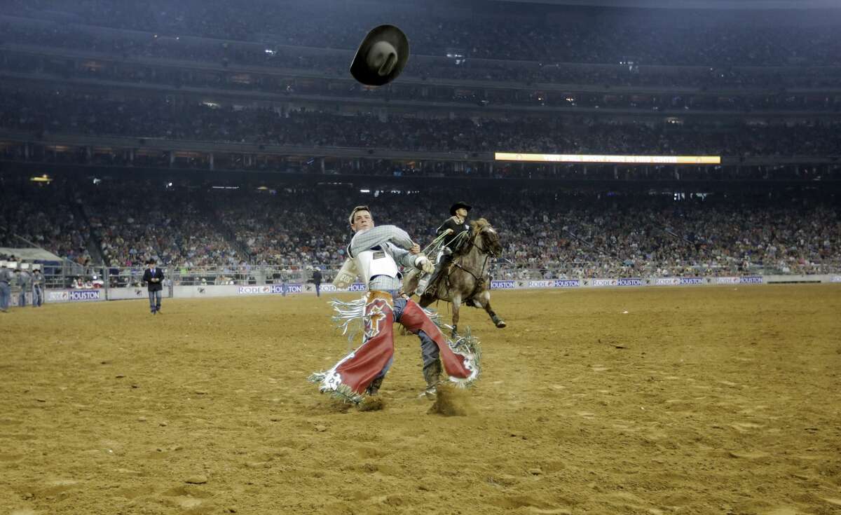 Tim O'Connell throws his hat into the air after a strong bareback ride during the Houston Rodeo on Sunday, March 26, 2017, in Houston. ( Elizabeth Conley / Houston Chronicle )