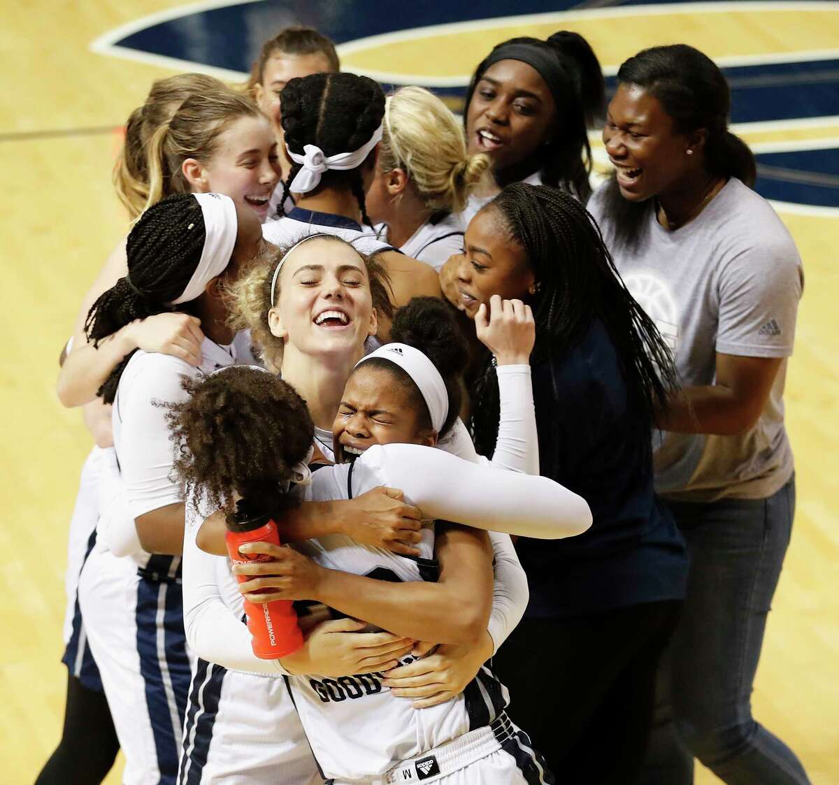 Tournament MVP Maya Hawkins, center, gets a hug from Rice's Jasmine Goodwine as the Owls celebrate winning the Women's Basketball Invitational title.