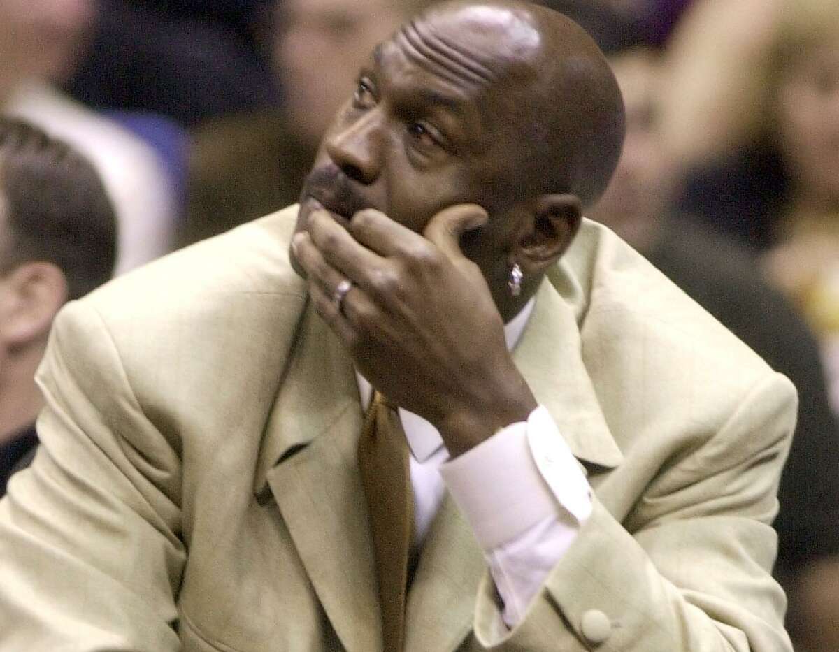 Washington Wizards guard Michael Jordan sits on the bench during the game againt the Spurs on Dec. 4, 2001, in San Antonio. Jordan sat out because of a knee injury.