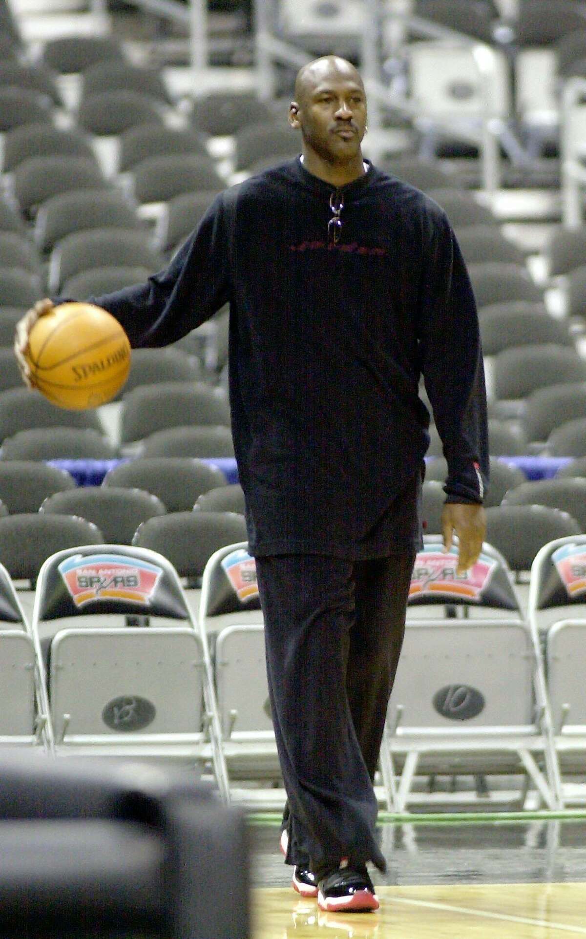 Injured star Michael Jordan wears street clothes to shootaround at the Alamodome in 2001.