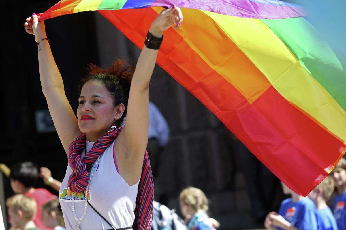 Erika Flores Casasola, of San Antonio, raises the gay pride flag during a rally in front of the state Capitol building, Monday, March 20, 2017. Members and supporters of the LGBTQ community rallied and voiced their opposition to SB6. Known as the bathroom bill, it regulates the usage of the facilities by making transgender people use the bathroom based on their birth gender.