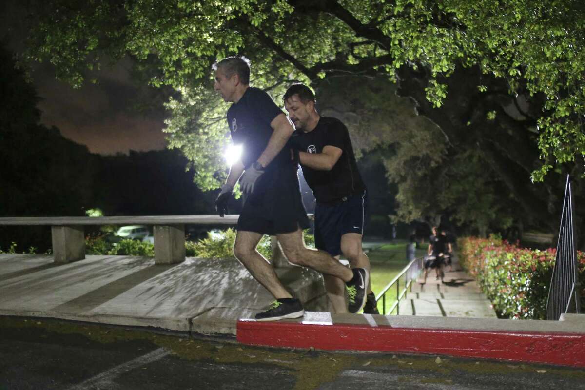 Francisco Robelo, left, and James Andrews, make it to the top of the stairs during a wheelbarrow exercise at a boot camp workout in the parking lot of St. Luke's Episcopal Church. They are members of the F3 boot camp workout group. F3 stands for fitness, fellowship and faith and is open free of charge to men. The workout ends with a Circle of Trust.